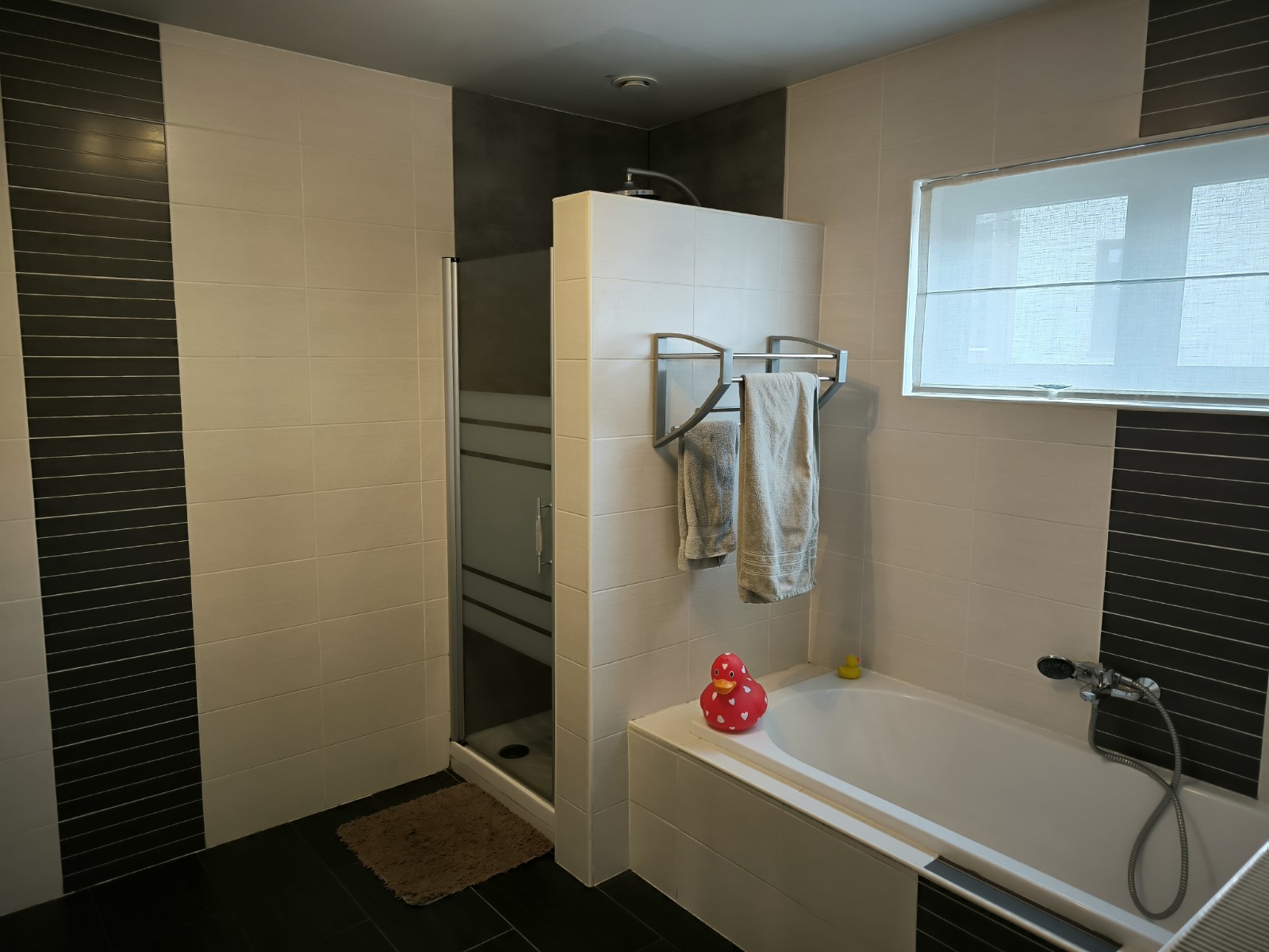 Foto van de badkamer met bad en douche