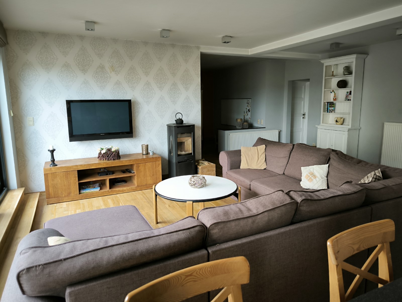 Foto van de woonkamer met zetel, kachel en tv